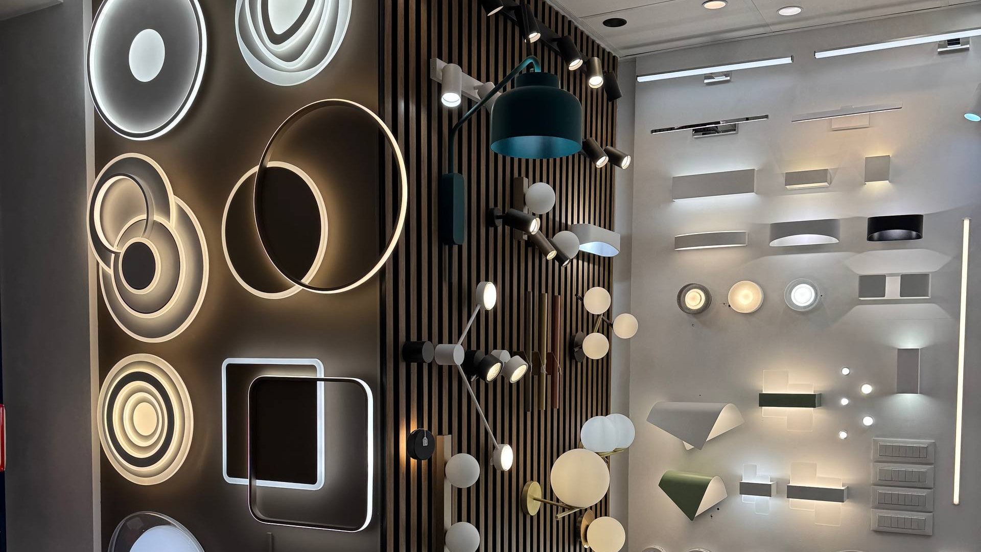 Parete espositiva con applique, plafoniere e profili LED accesi