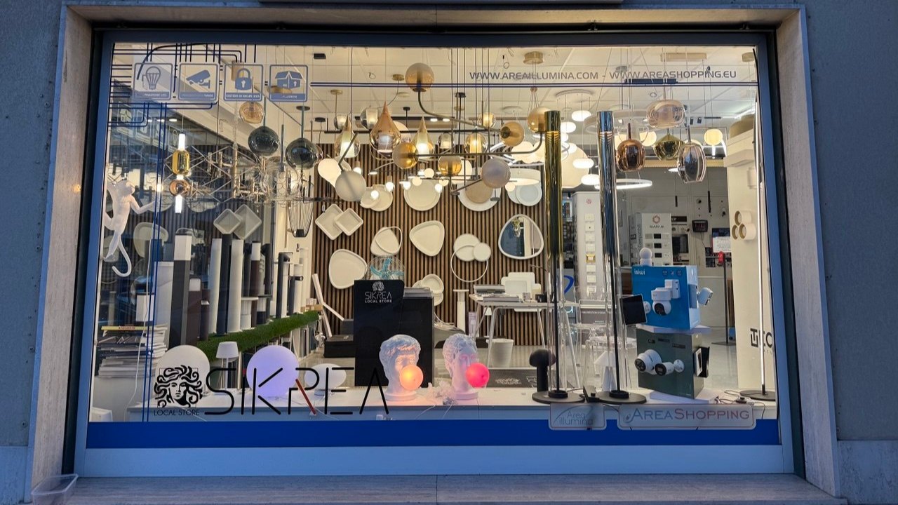 Interno dello showroom con il bancone illuminato e il logo Area Illumina