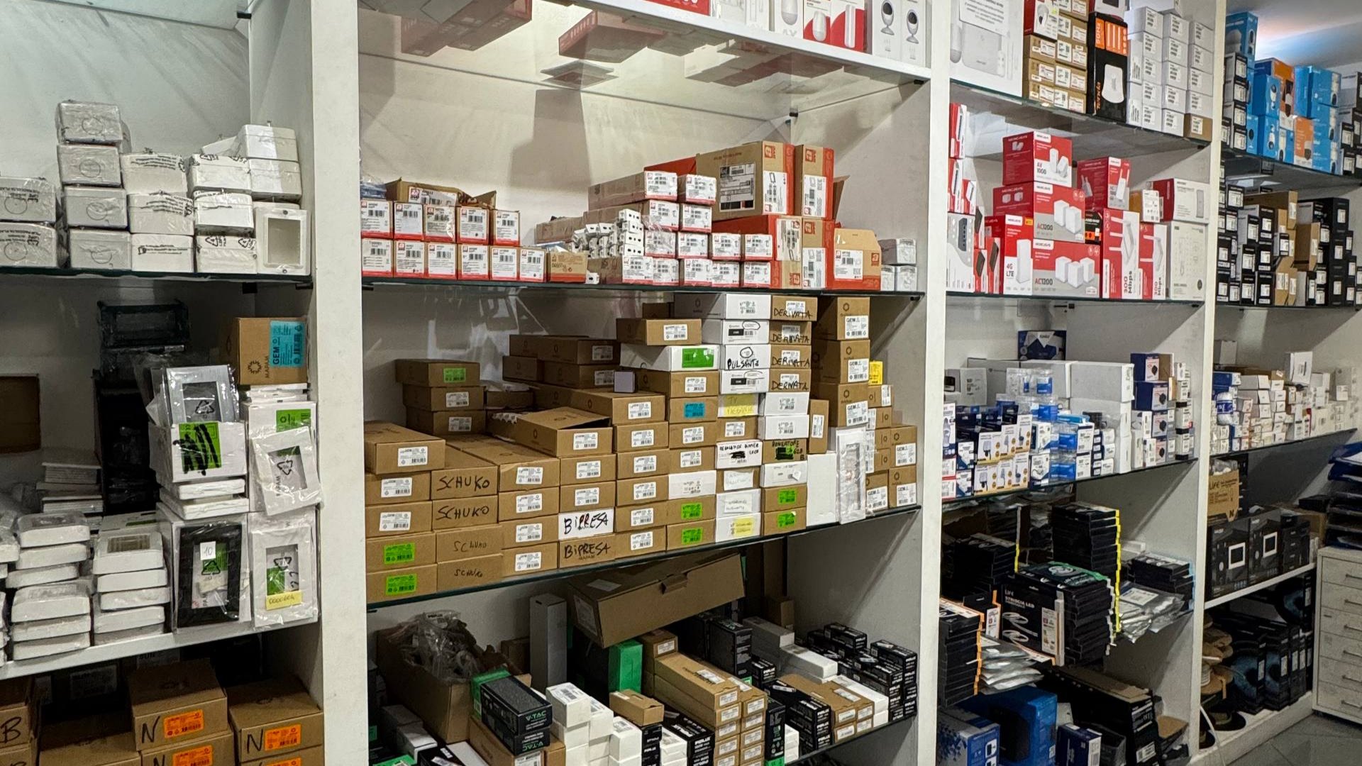 Sospensioni in vetro ambra e fumé accese sotto il soffitto dello showroom