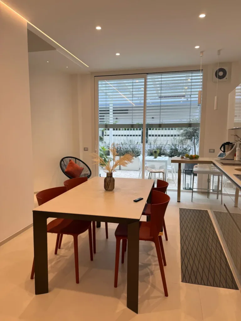 Tavolo da pranzo con sedie rosse sotto una linea di luce a soffitto