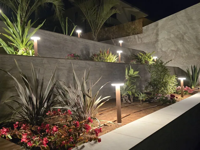 Paletto in corten acceso tra le piante di una terrazza