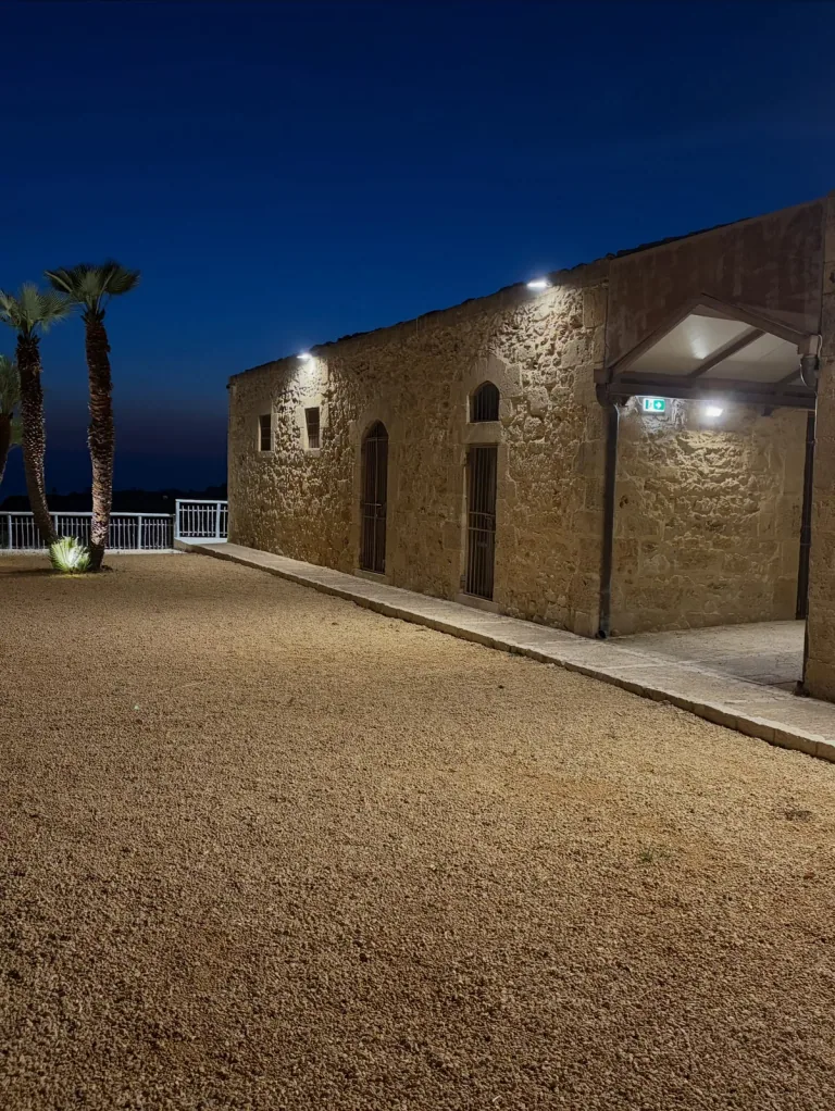 Cortile del museo con le facciate in pietra illuminate e le palme