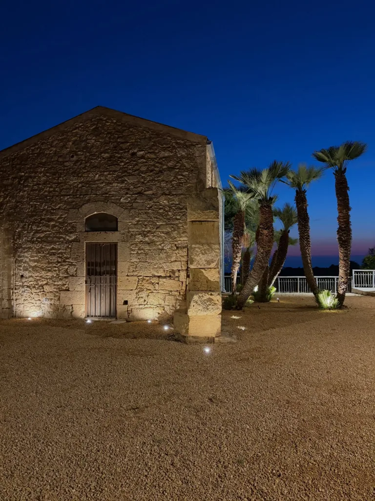 Facciata in pietra con portale ad arco illuminata dal basso