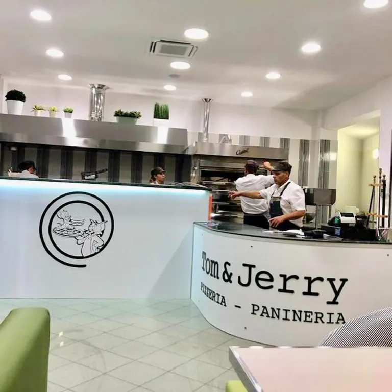 Banco della pizzeria Tom & Jerry con il logo e la cucina a vista