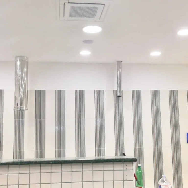 Soffitto della pizzeria con faretti a incasso accesi sopra il banco